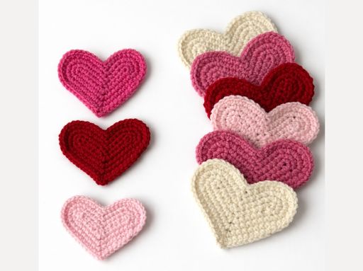 Six crocheted hearts in pink, red, and cream are arranged in two rows on white; text: "HOW TO CROCHET A HEART. Free crochet pattern