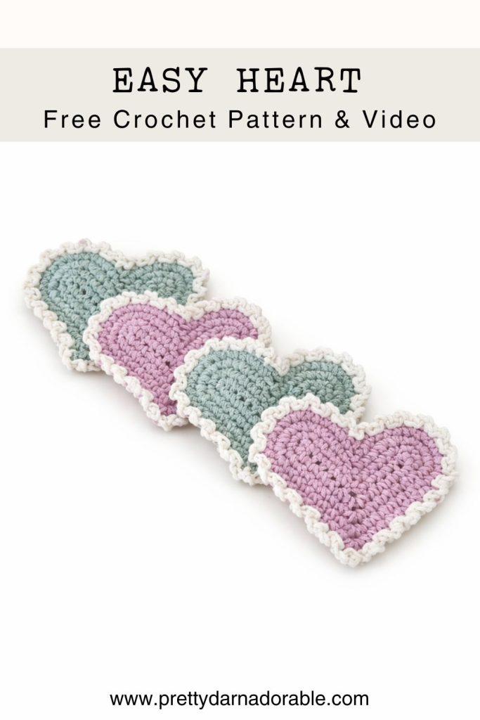 Four heart-shaped crocheted coasters in pink and green with white edges, arranged diagonally. Text: Free Crochet Heart Pattern, video tutorial at prettydarnadorable.com. Free crochet pattern