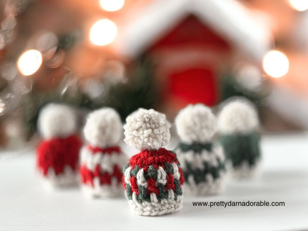 three mini crochet hat ornaments for christmas in red green and white