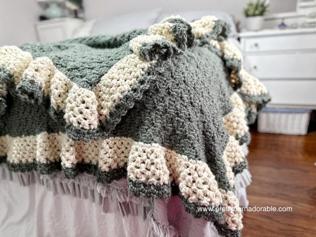 green crochet blanket with cream scalloped border