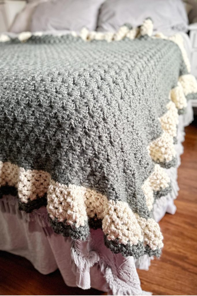 green crochet blanket with cream scalloped border