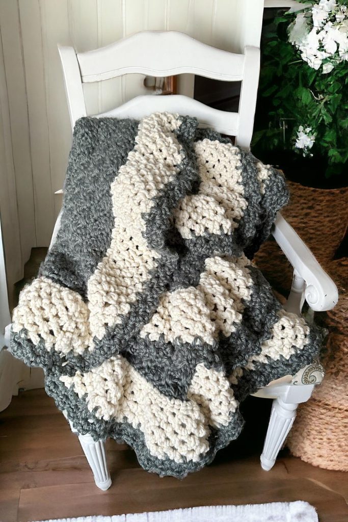 green crochet blanket with cream scalloped border