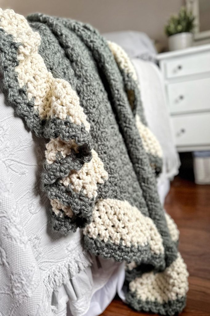 green crochet blanket with cream scalloped border