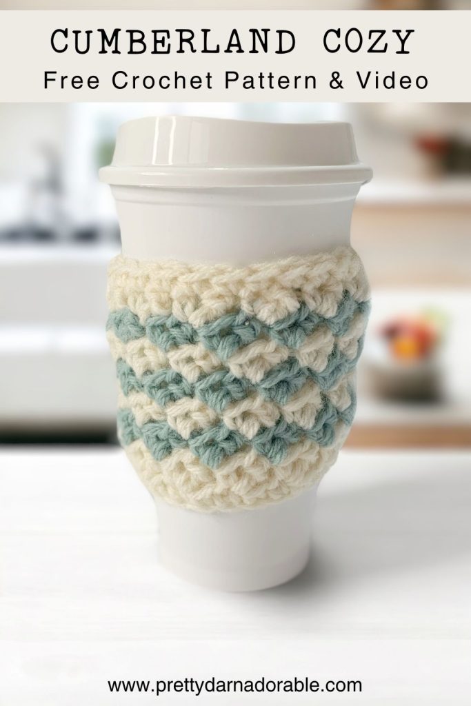 a coffee cup with a crocheted coffee cozy on it