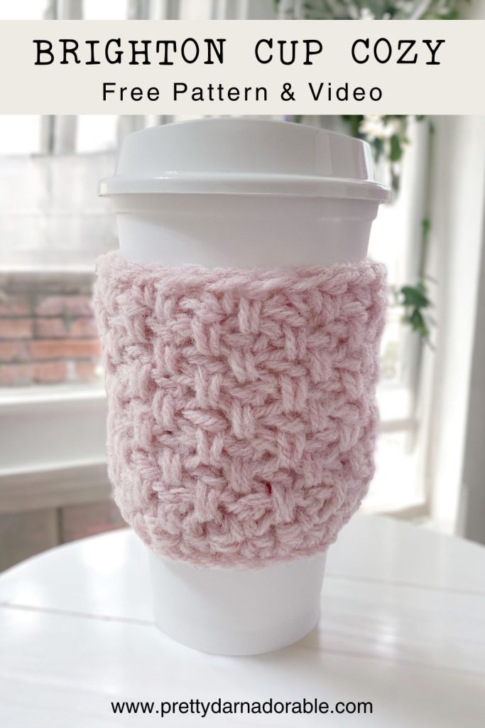 pink crochet cup cozy in front of a window