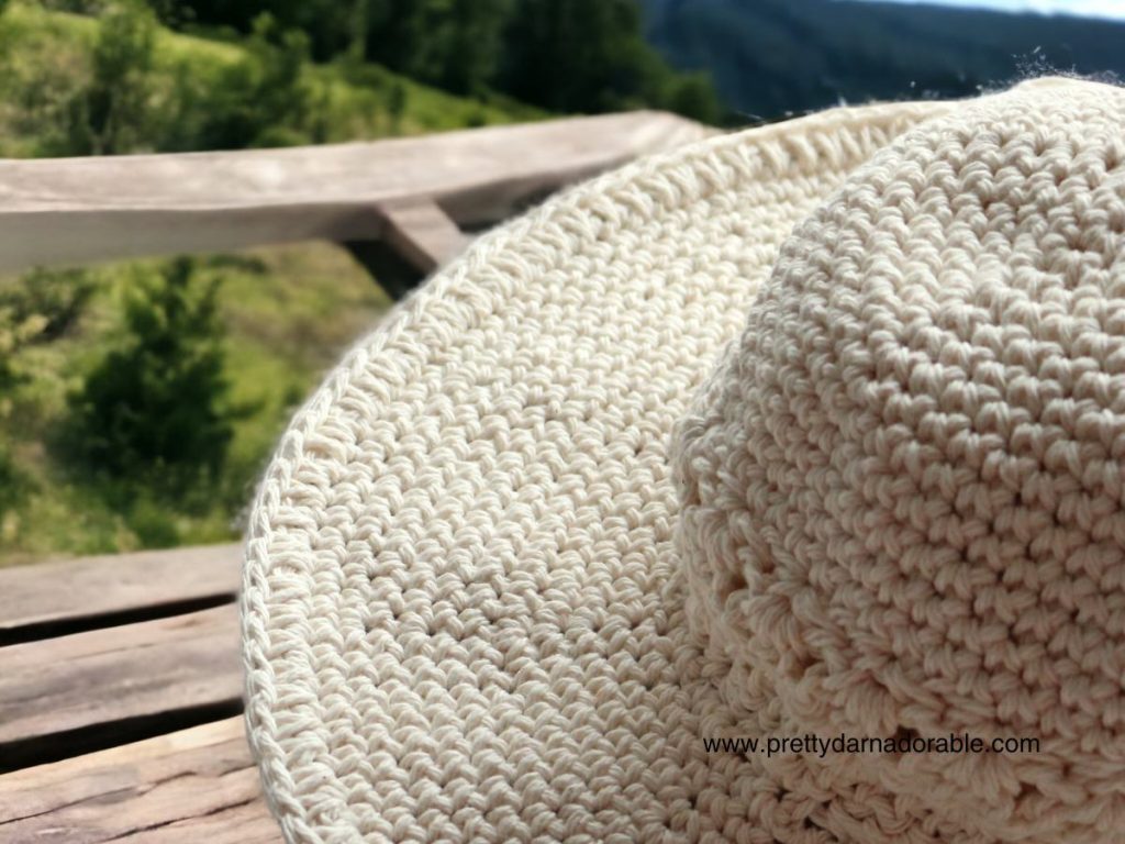 cream crochet sun hat with a wide brim and lacey texture