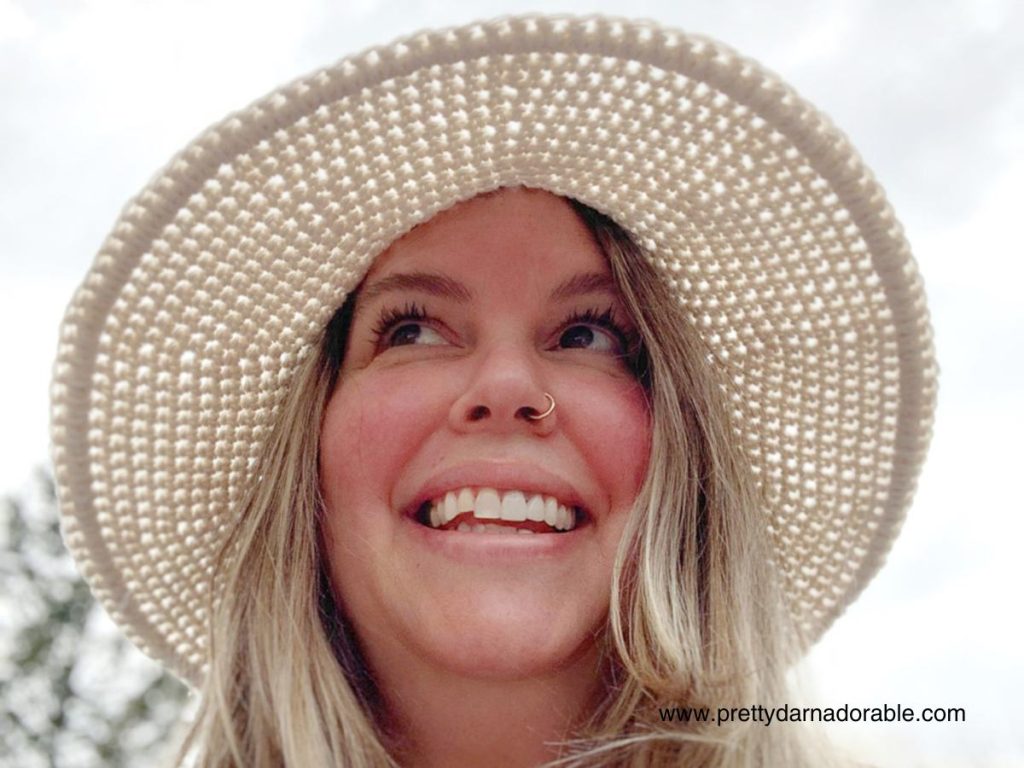 lady wearing cream crochet sun hat with a wide brim and lacey texture