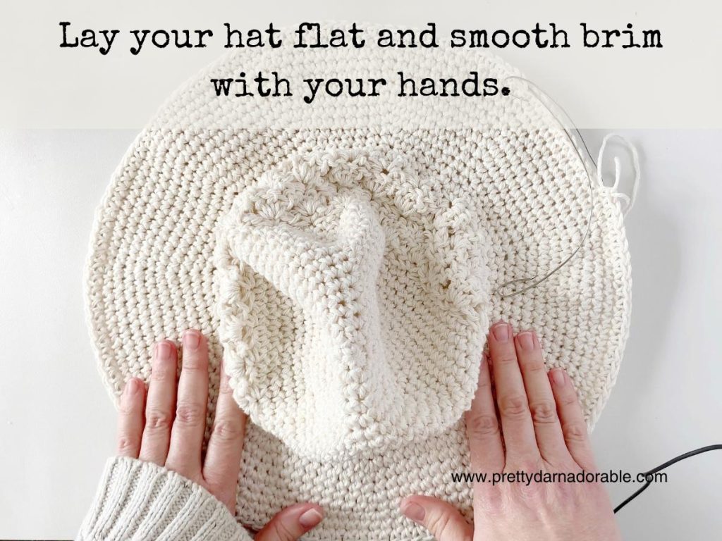 hands flattening the brim of the sun hat