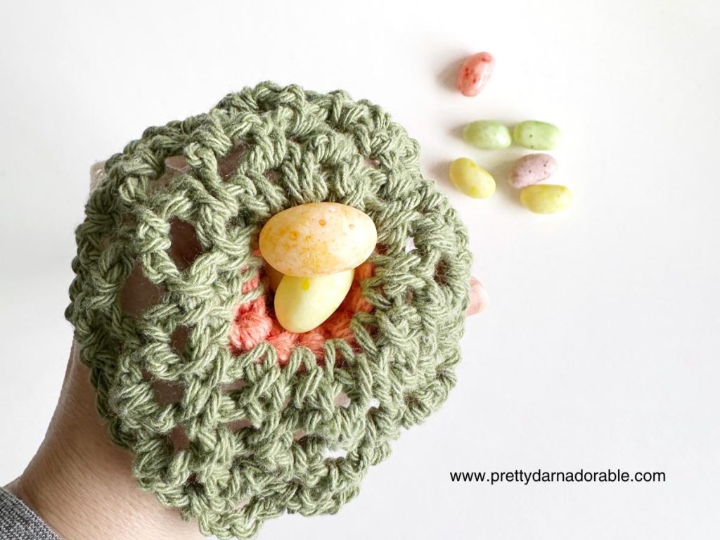 top of a crochet carrot with candy eggs inside
