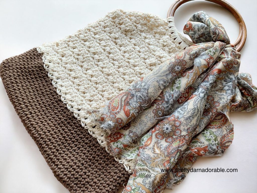 Cream crochet tote bag with brown bottom and round wooden handles