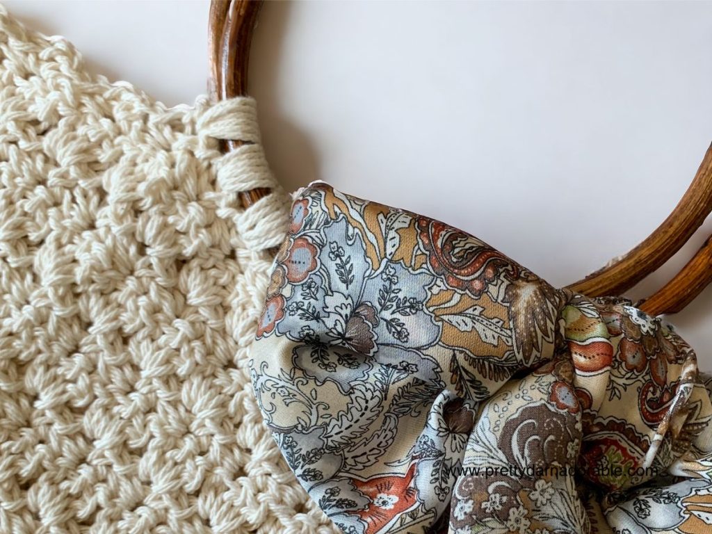 Cream crochet tote bag with brown bottom and round wooden handles