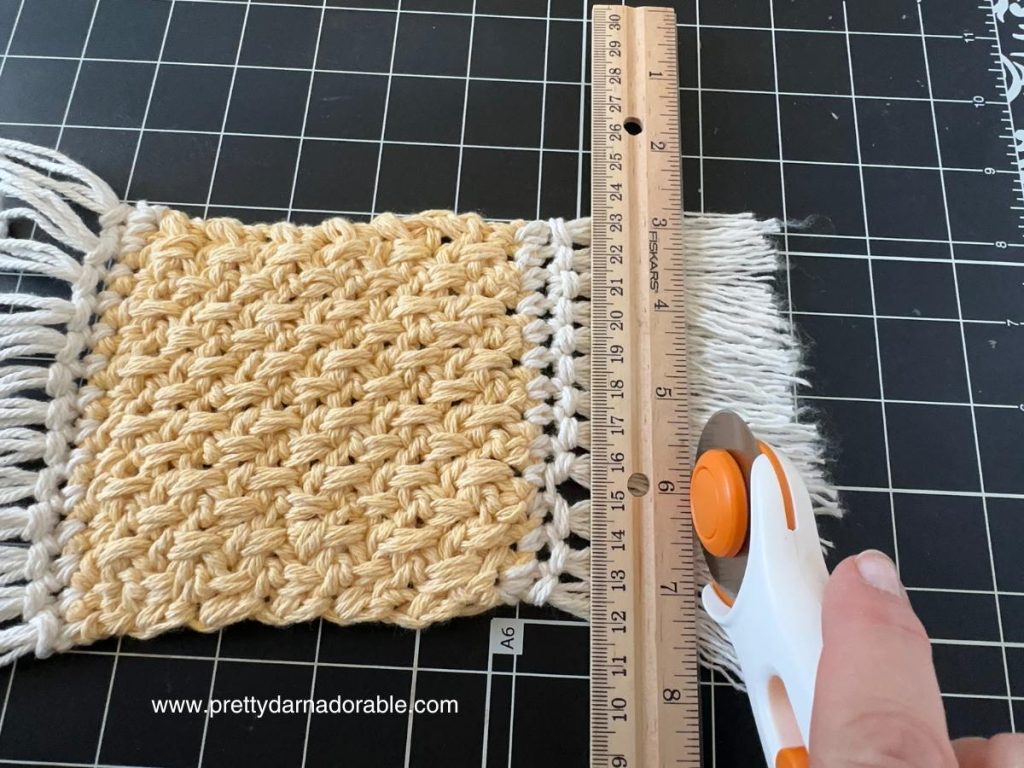crochet fringe being cut with a rotary cutter