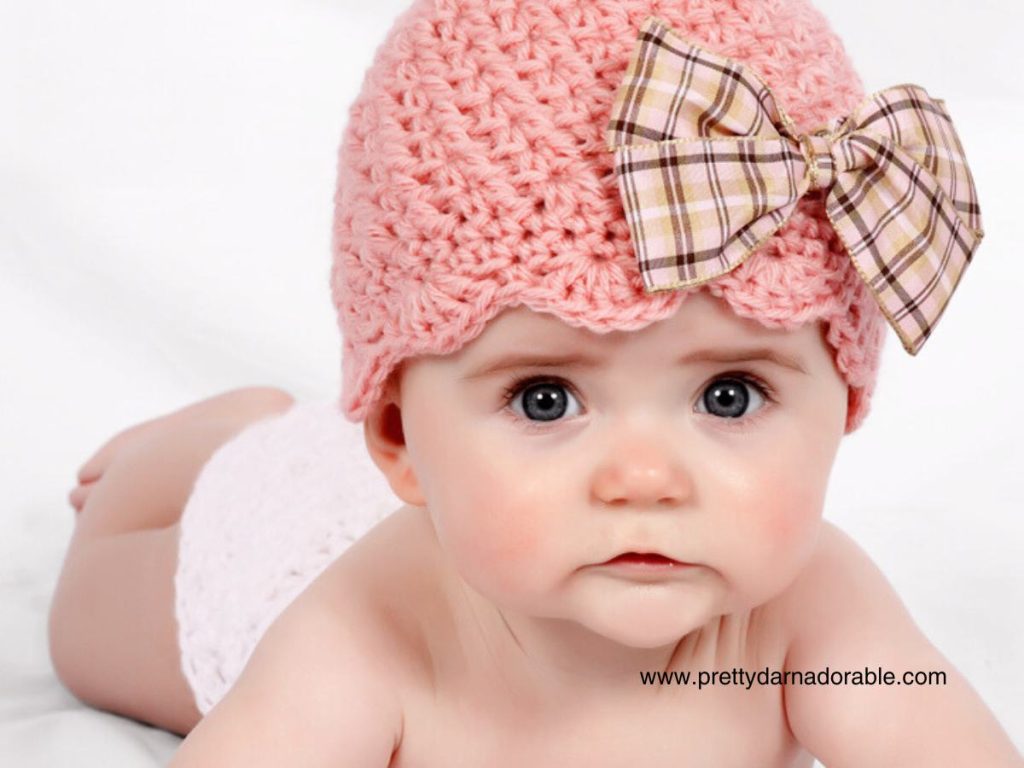 baby girl wearing pink crochet hat with bow - free crochet beanie hat pattern