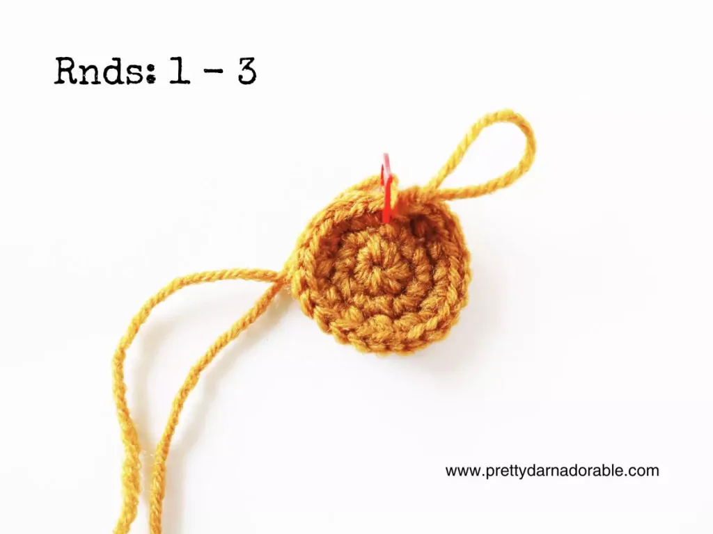 Small yellow crocheted circle with yarn tail and stitch marker on white background, labeled Rnds: 1 - 3, www.prettydarnadorable.com. Free crochet pattern