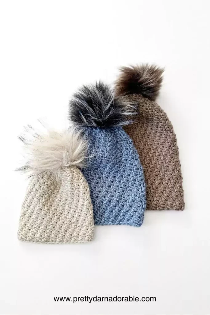 a group of crochet slouch hats with pom poms
