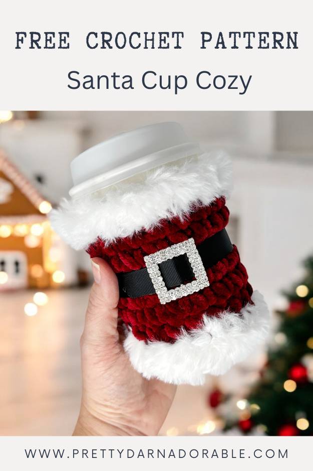 red crochet cup cozy with fur trim rhinestone buckle and black belt - looks like santa with christmas theme in the background