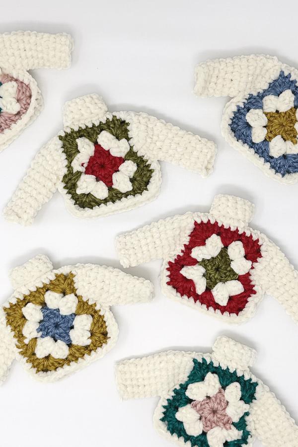 display of crochet granny square christmas tree ornaments laying on a white background