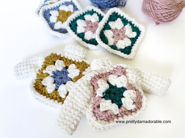 2 granny square sweater ornaments laying on a white backtround