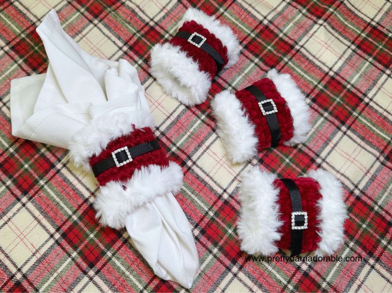 red napkin ring with white fur trim with black belt and rhinestone buckle