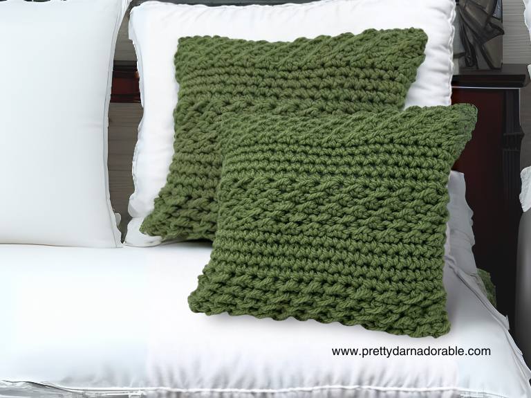 two crochet pillows on a white bed