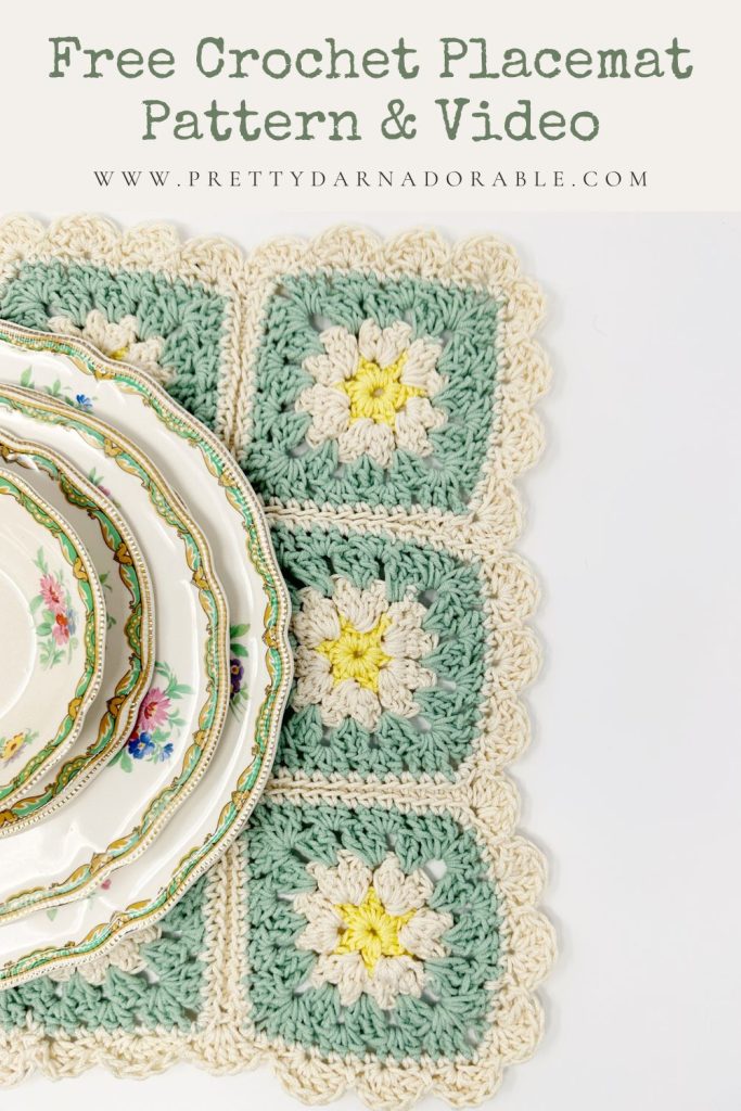 A pastel crochet placemat with floral square patterns is partially covered by stacked, vintage floral china plates—perfect kitchen decor. Text above reads, Free Crochet Placemat Pattern & Video www.prettydarnadorable.com.