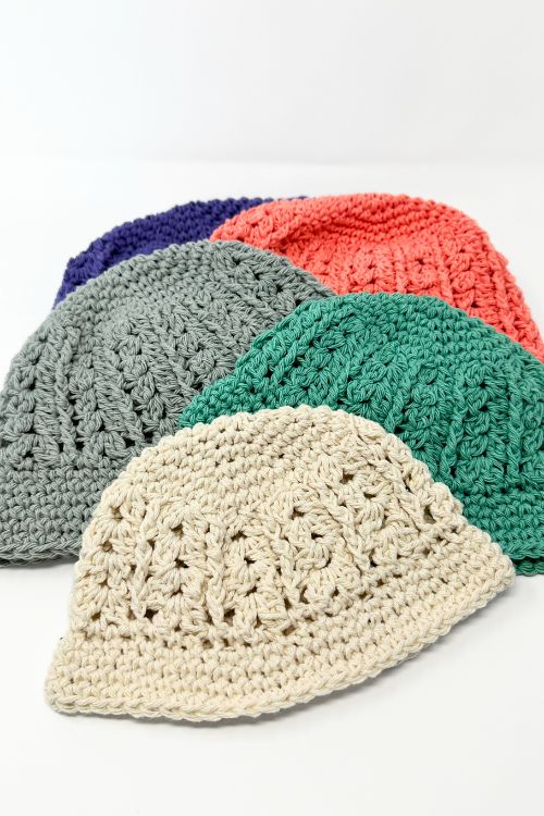 a group crocheted hats are laid out on top of each other