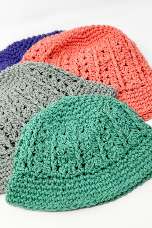 a group crocheted hats are laid out on top of each other