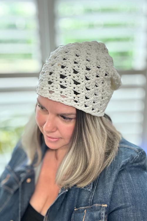 woman wearing cream crochet granny stitch hat made with cotton yarn