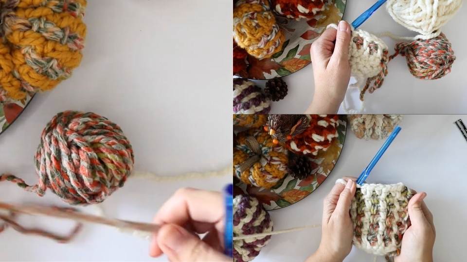 Hands crochet with a blue hook and chunky multicolored yarn, surrounded by yarn pumpkins and balls on a white surface.