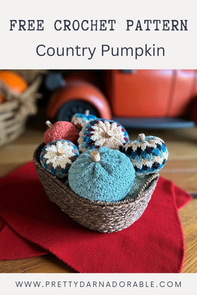 a basket filled with crocheted pumpkins and yarn