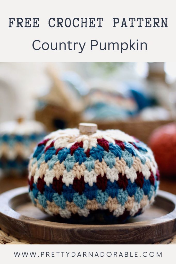 a crochet striped pumpkin in aquas beige and red