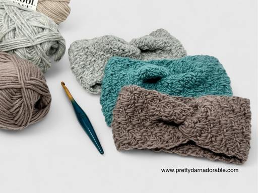 Three crocheted headbands in gray, teal, and taupe lie beside a blue crochet hook and yarn balls. www.prettydarnadorable.com appears. Free crochet pattern