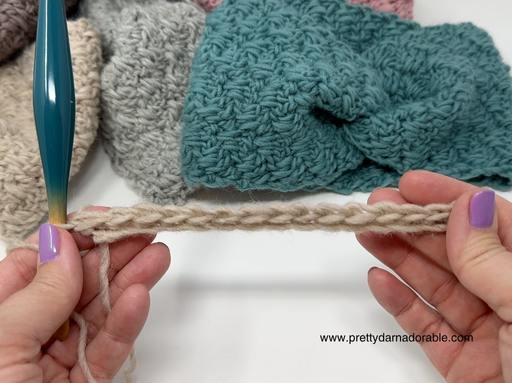 Hands with lavender nails hold a crochet chain beside a teal hook; soft-hued crocheted swatches and www.prettydarnadorable.com appear. Free crochet pattern
