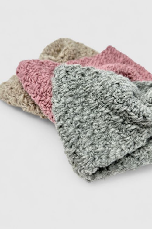 Stack of three crocheted washcloths in gray, pink, and beige on a white background, showing their textured stitches. Free crochet pattern
