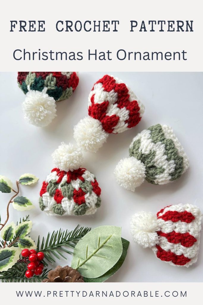 Five crocheted Christmas hat ornaments with red, white, and green pom-poms on a white surface with greenery and berries. Text: Christmas Hat Ornament. Free crochet pattern