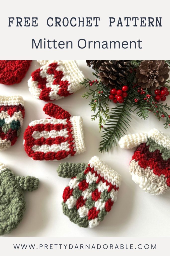 Colorful crocheted mitten ornaments on a white surface with pine, red berries, pinecone, and text: Free Crochet Pattern Mitten Ornament. Free crochet pattern