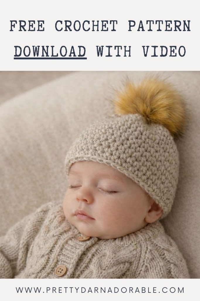 Sleeping baby in a beige sweater and crocheted hat with faux fur pom-pom. Text: "Free Crochet Pattern Download With Video." Website: www.prettydarnadorable.com. Free crochet pattern