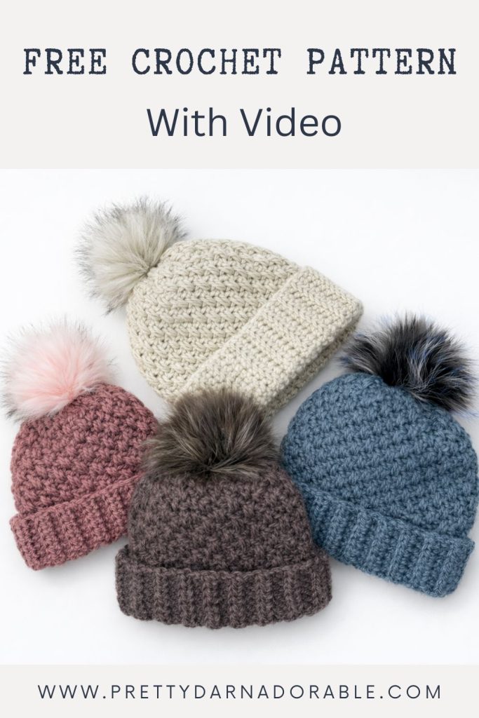 Four crocheted beanies with pom-poms in cream, pink, brown, and blue on white. Text: Free Crochet Pattern With Video and www.prettydarnadorable.com. Free crochet pattern