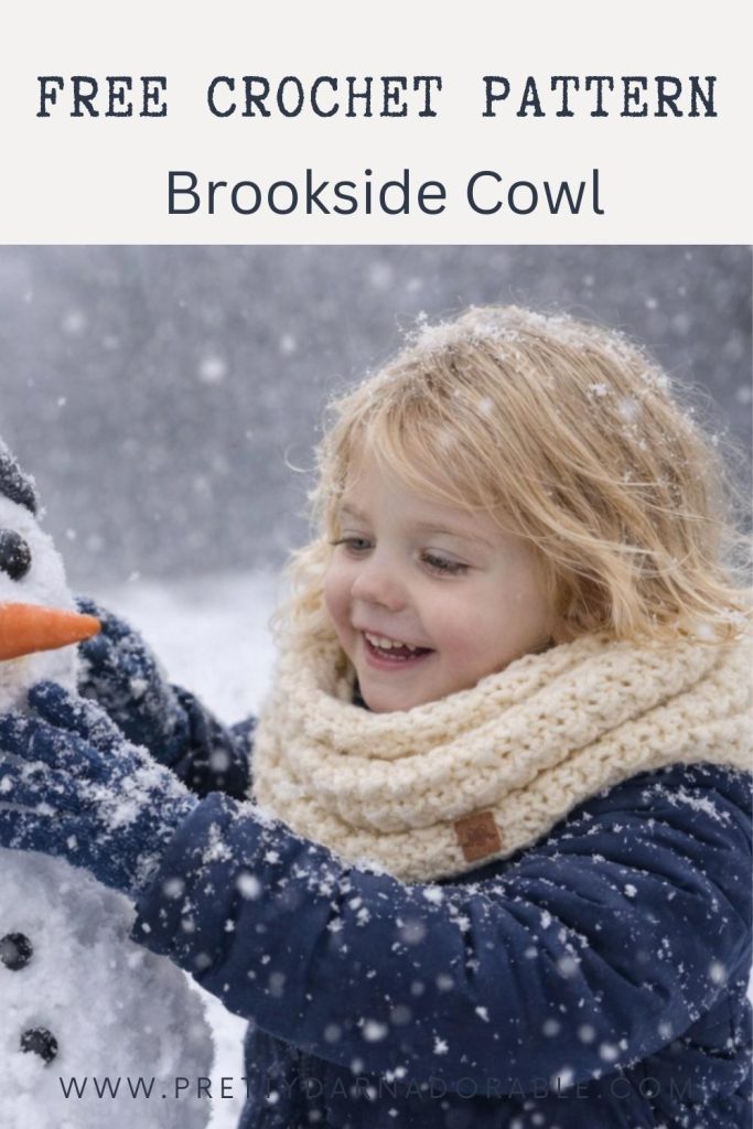 A smiling child in a red coat holds a white snowman with a scarf, standing outside in the snow; no text visible. Free crochet pattern