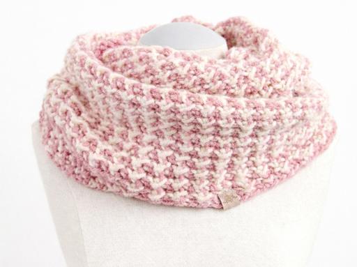 A soft pink and white textured infinity scarf drapes around a white mannequin bust, set against a plain white background. Free crochet pattern