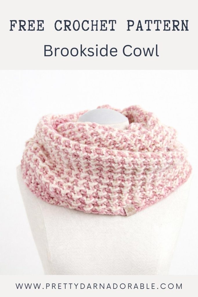 Pink and white textured crochet cowl on a white mannequin; text reads "Free Crochet Pattern, Brookside Cowl," with website link below. Free crochet pattern