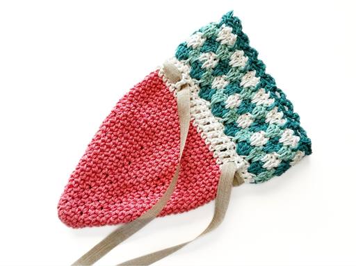 Handmade crochet drawstring pouch with a pink base, green and white top, beige drawstring, set on a white background. Free crochet pattern
