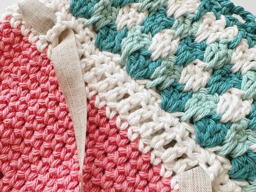 Close-up of crocheted fabric in pink, cream, and teal with a beige ribbon; text promotes Crochet Carrot Treat Bag Pattern. Free crochet pattern