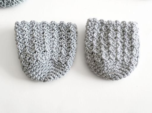 Two small, light gray crocheted pieces with rounded bottoms and textured stitching sit side by side on a white surface. Free crochet pattern