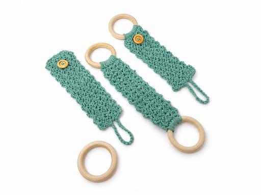 Three teal crochet keychain holders with wooden rings and yellow buttons sit on a white background next to an extra wooden ring. Free crochet pattern