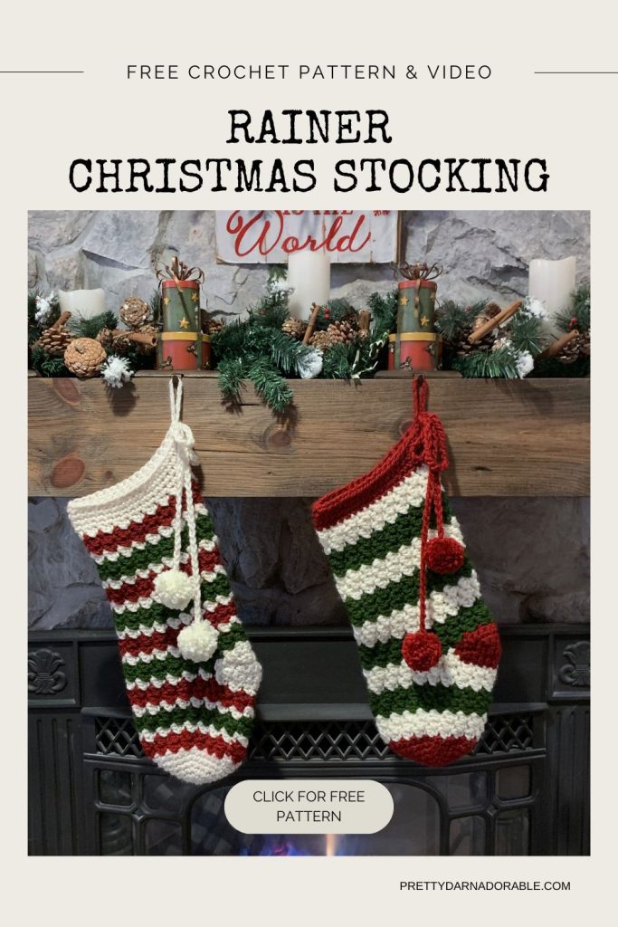 Two red, green, and white crocheted Christmas stockings hang from a fireplace adorned with candles, pine branches, and pinecones. Visible text promotes a free crochet pattern and video for making the stockings. Free crochet pattern