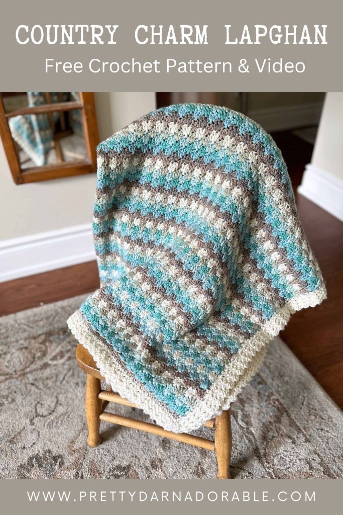 A blue, brown, and cream crocheted lapghan is draped over a wooden chair, with a matching rug and a mirror in the background. Text on the image promotes a free crochet pattern and video. Free crochet pattern