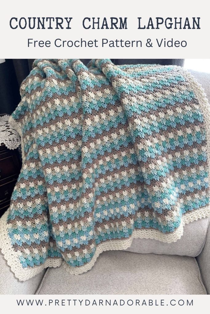 A striped crocheted lapghan in blue, gray, brown, and cream is draped over a sofa. The image includes the text “Country Charm Lapghan Free Crochet Pattern & Video” at the top and “www.prettydarnadorable.com” at the bottom. Free crochet pattern